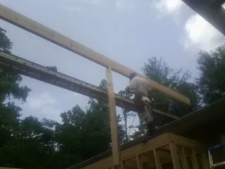 Carpenter setting a ridge beam over a new addition frame — Ice Dam Removal by Roofing Brothers in Stanfield