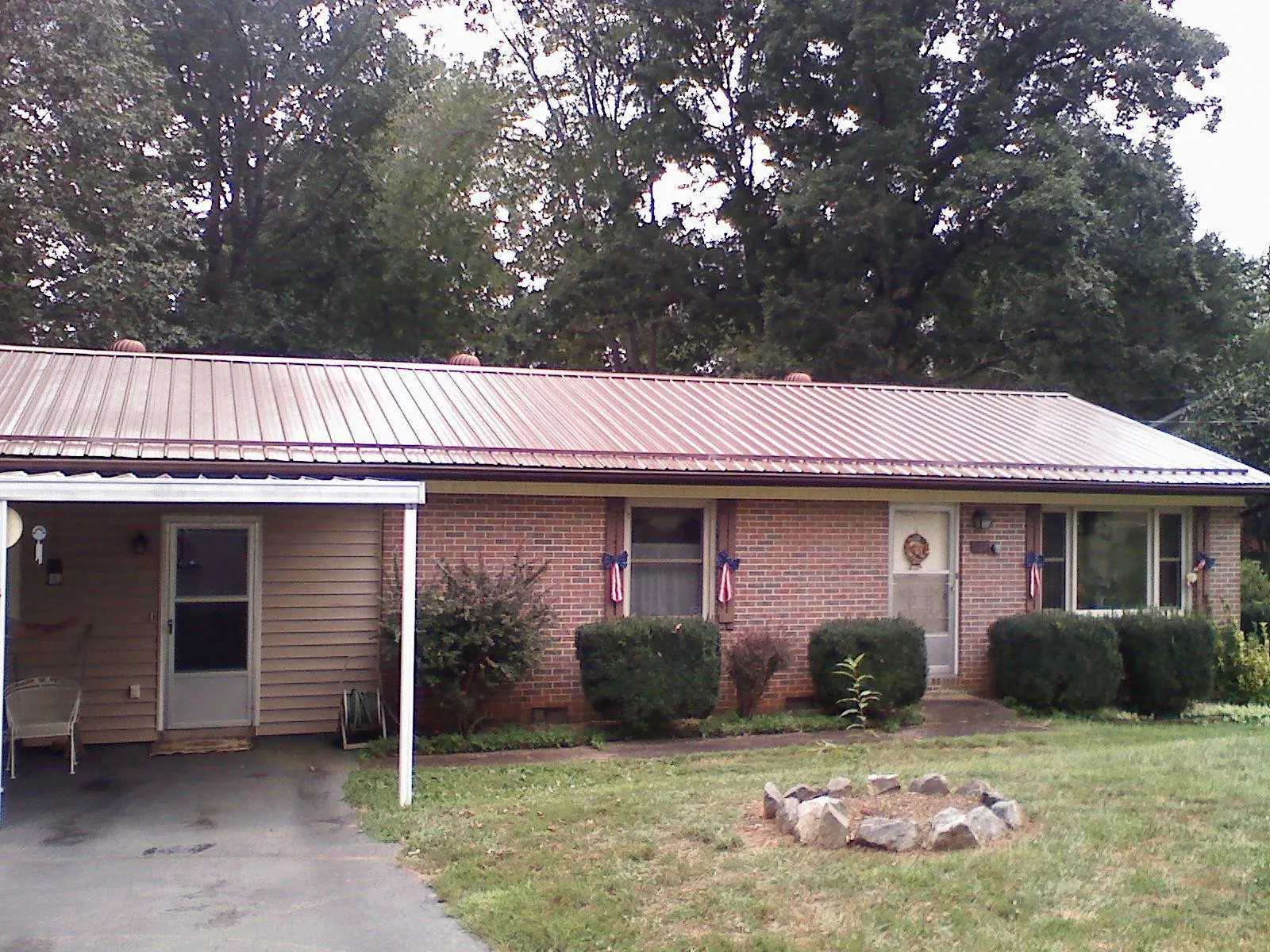Bronze metal roof and carport on a brick ranch home — Roof Repair work by our crew in Stanfield